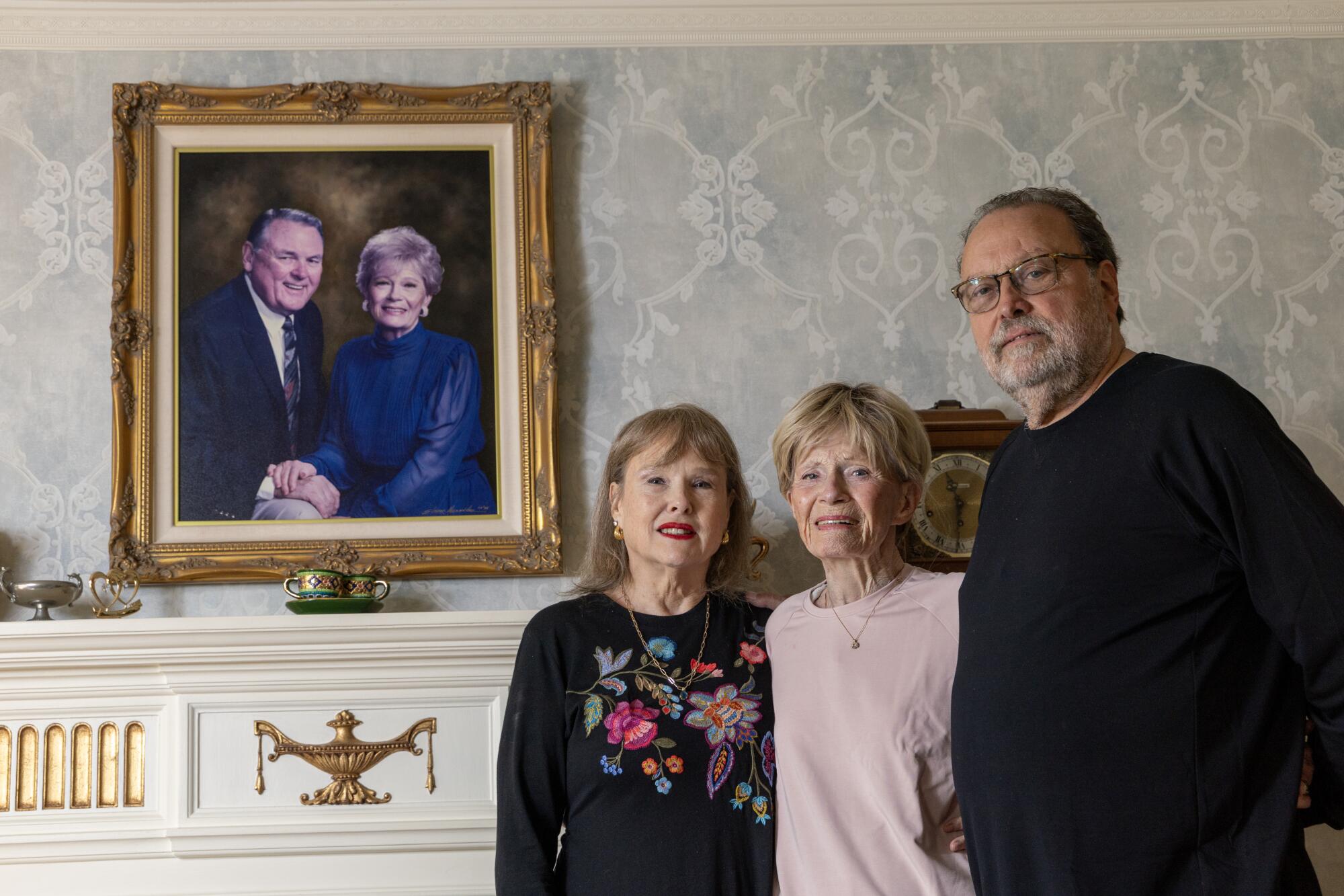 Melanie Jackson, left, Turi Ann Jackson and Sam Cracchiolo, Melanie's husband, stand in front of a portrait.