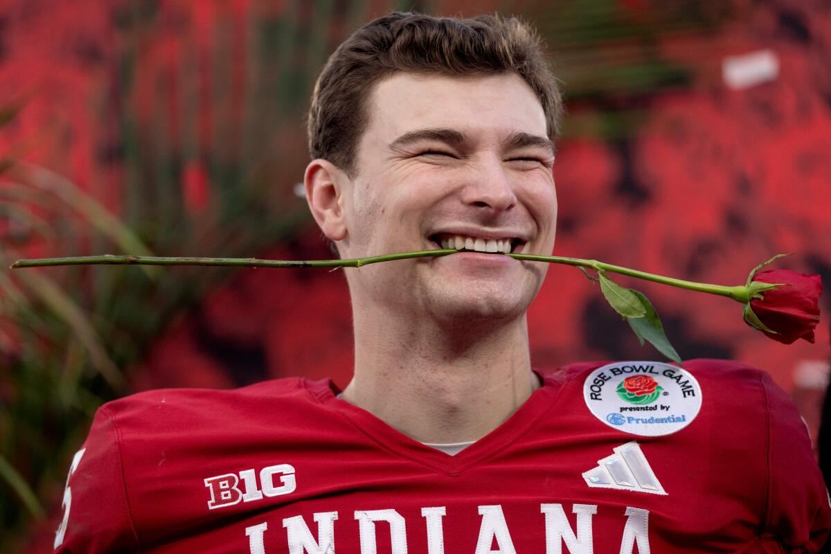 Fernando Mendoza celebrates with a rose in his mouth after Indiana's win.