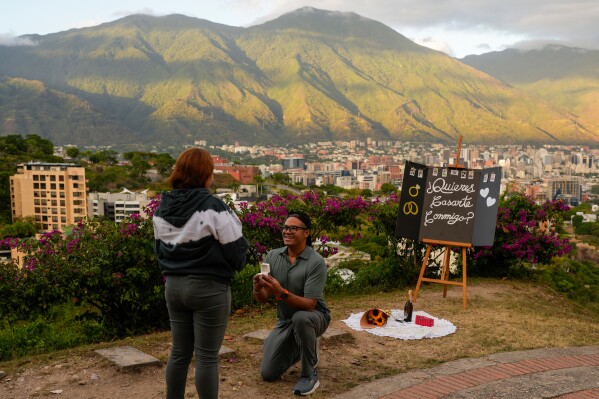 Jose Saavedra proposes to Mariele Munoz at the Valle Arriba viewpoint in Caracas, Venezuela, Dec. 30, 2025. (AP Photo/Matias Delacroix, File)