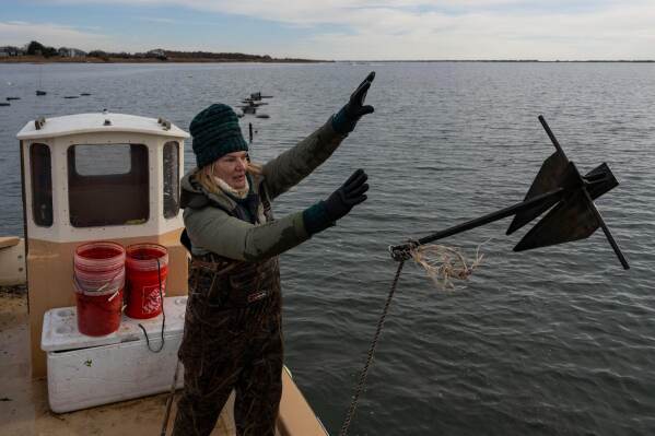 Retired WNBA star and Hall of Famer Sue Wicks throws an anchor from her boat in Moriches Bay in New York, Thursday, Nov. 20, 2025. (AP Photo/Yuki Iwamura)