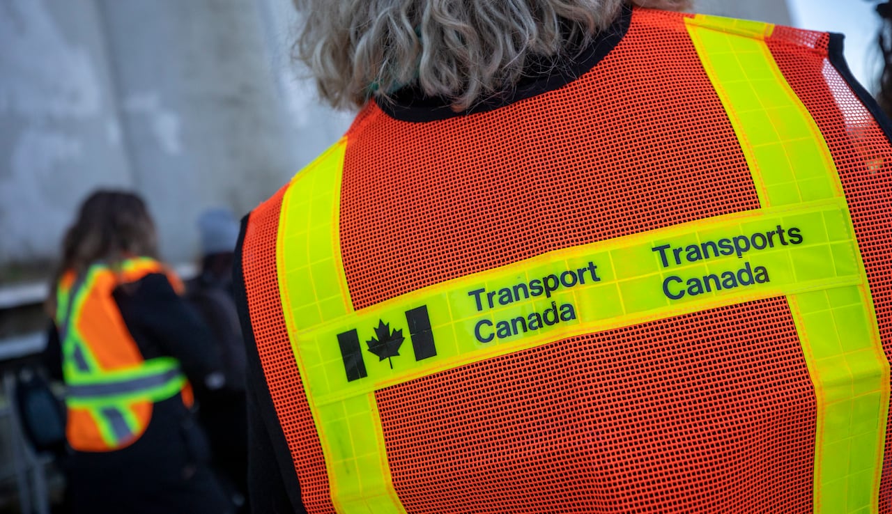 A person seen from behind wearing a high-vis vest reading 'Transport Canada'.