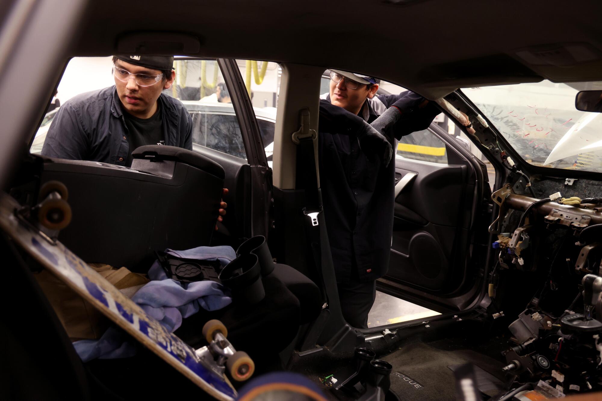 Two people look into a car.