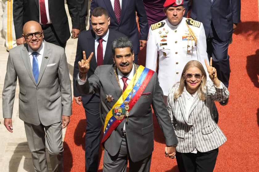 Venezuelan President Nicolas Maduro and first lady Cilia Flores flash victory signs as they arrive to the National Assembly for the annual presidential address, in Caracas, Venezuela, Jan. 15, 2024. As the July 28 presidential election nears, Venezuelan government keeps arresting opponents allegedly tied to criminal plots.