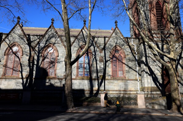 A Brown University student walks past a church on the Providence, RI, campus, Thursday, Dec. 18, 2025. (AP Photo/ Mark Stockwell)