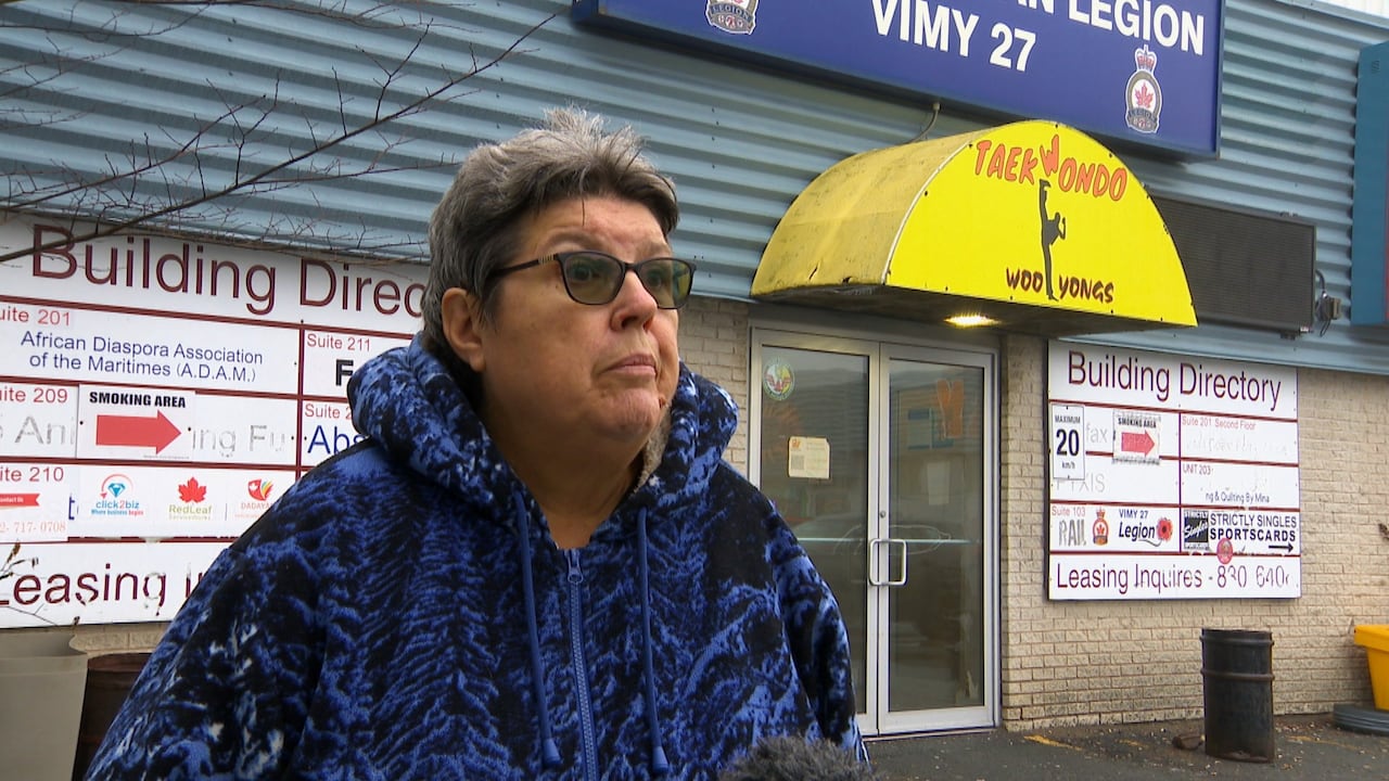 Gwen stands outside in front of the legion