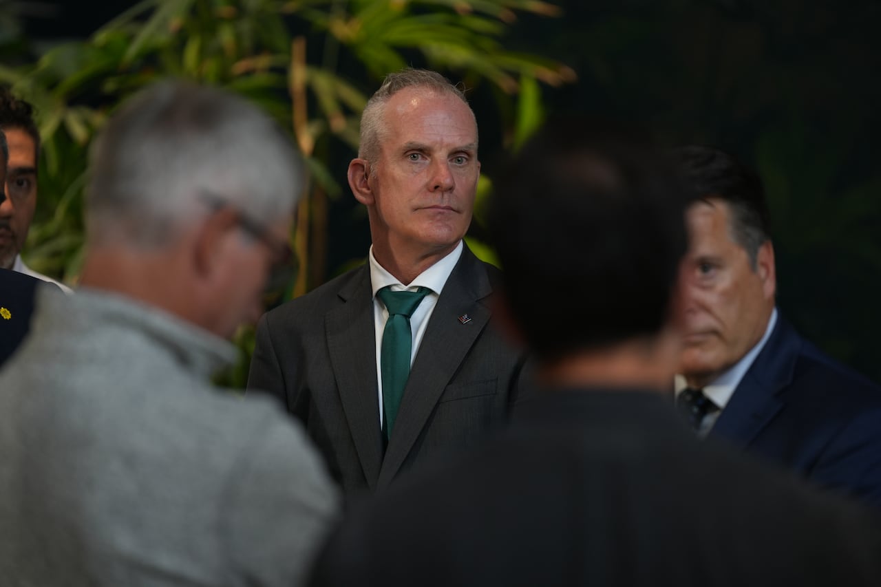 A man stands in a crowd wearing a suit.