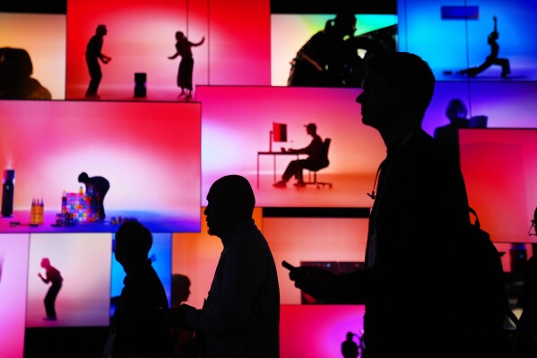 People pass an LG Electronics display during the CES tech show Tuesday, Jan. 6, 2026, in Las Vegas. (AP Photo/Abbie Parr, File)