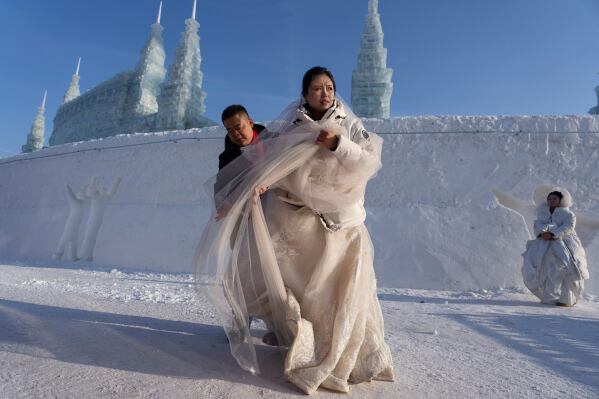 A couple prepares to take part in a mass wedding in sub zero temperatures during the annual Ice and Snow Festival held in Harbin in northeastern China's Heilongjiang province, Tuesday, Jan. 6, 2026. (AP Photo/Ng Han Guan, File)