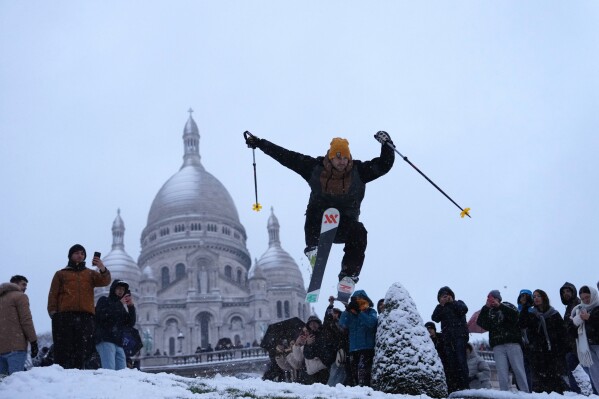 A man skies down the hill by the Sacre-Coeur basilica during a snowfall in the Montmartre district, Monday, Jan. 5, 2026 in Paris. (AP Photo/Aurelien Morissard, File)