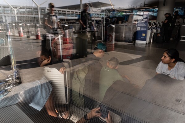 FILE - Travelers wait to check in for their flights at Los Angeles International Airport on Nov. 11, 2025. (AP Photo/Jae C. Hong)