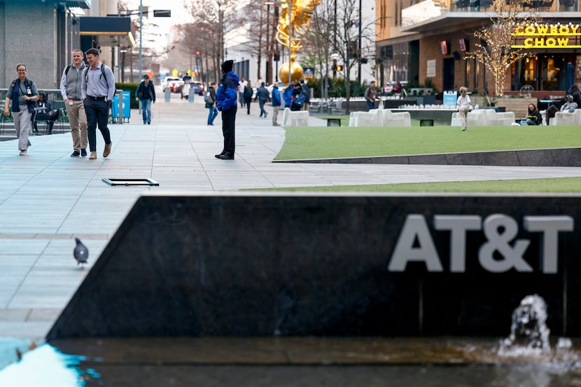 AT&T employees walk through the AT&T Discovery District outside AT&T headquarters in...