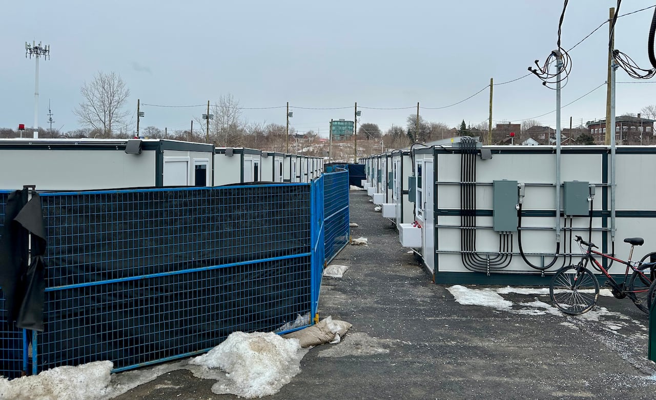 Two rows of identical tiny cabins separated by a fence. 
