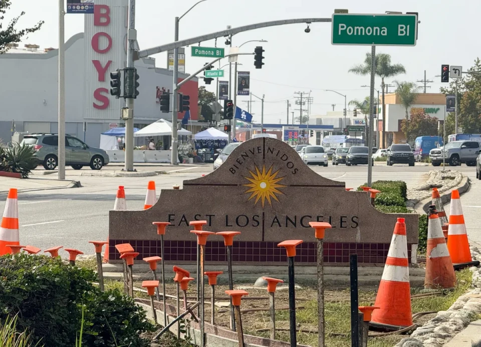 A signage in the middle of a street barrier that reads "Bienvenidos East Los Angles."