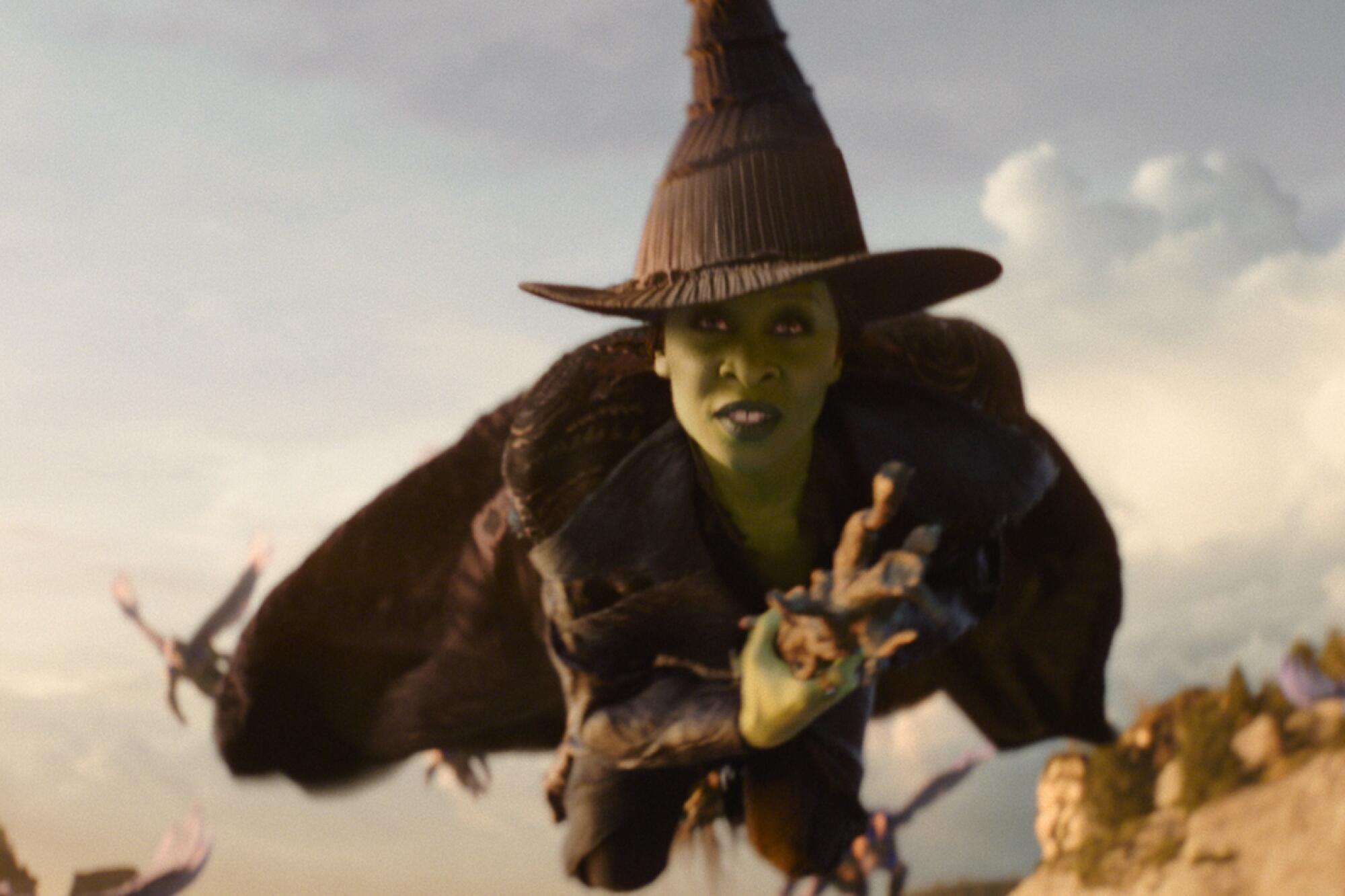 Cynthia Erivo in a witch hat riding through the air on a broomstick in "Wicked: For Good."