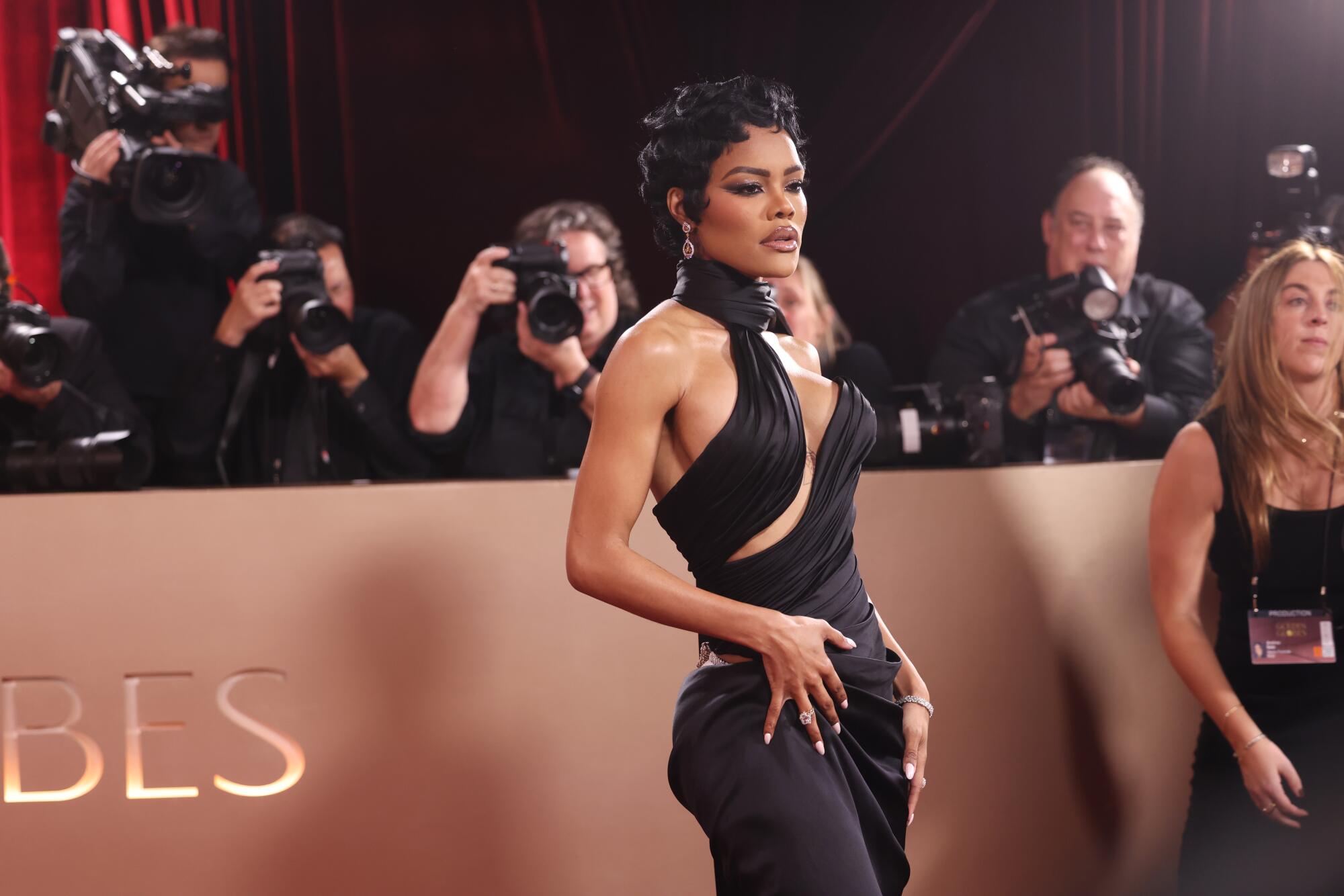 Teyana Taylor, in a black gown with cutouts, poses on the red carpet.  