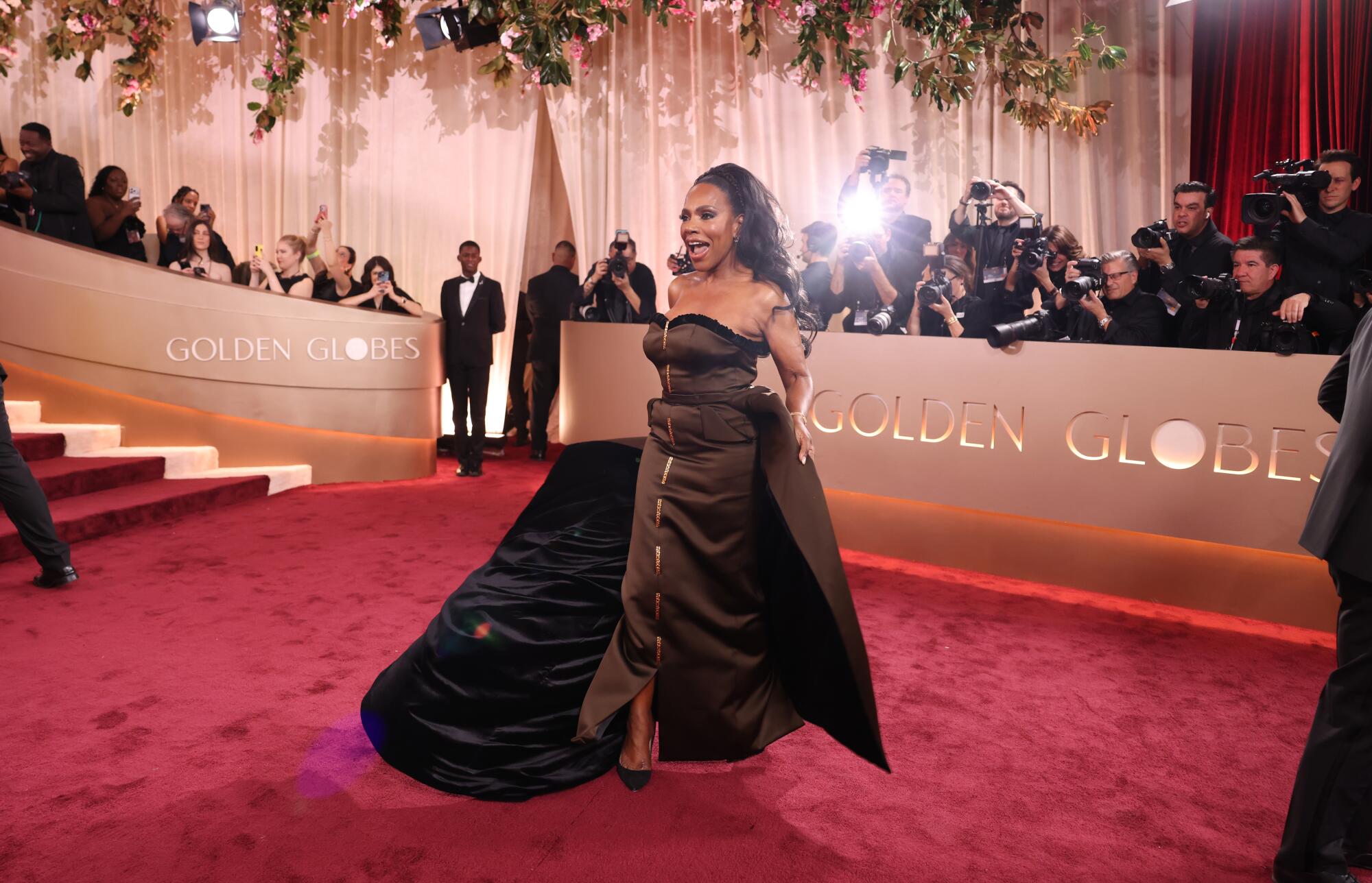 Sheryl Lee Ralph, in a brown gown, poses on the red carpet.