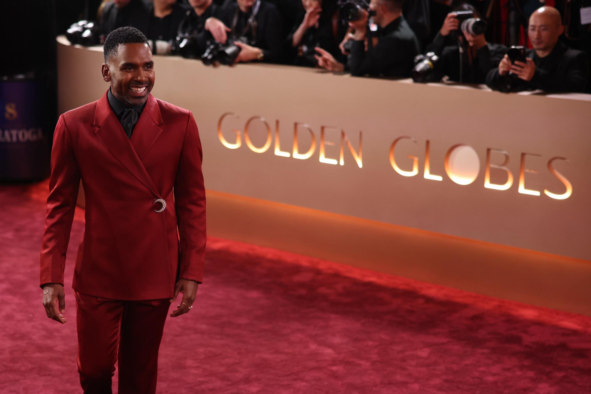 Justin Sylvester, in a red tux, walks the red carpet. 