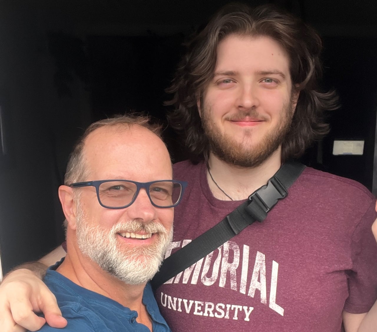 Two men in casual T-shirts smile for the camera.