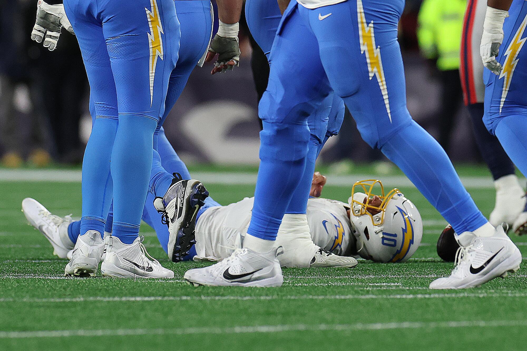 Chargers quarterback Justin Herbert is slow to get up after being sacked in the fourth quarter against the Patriots.