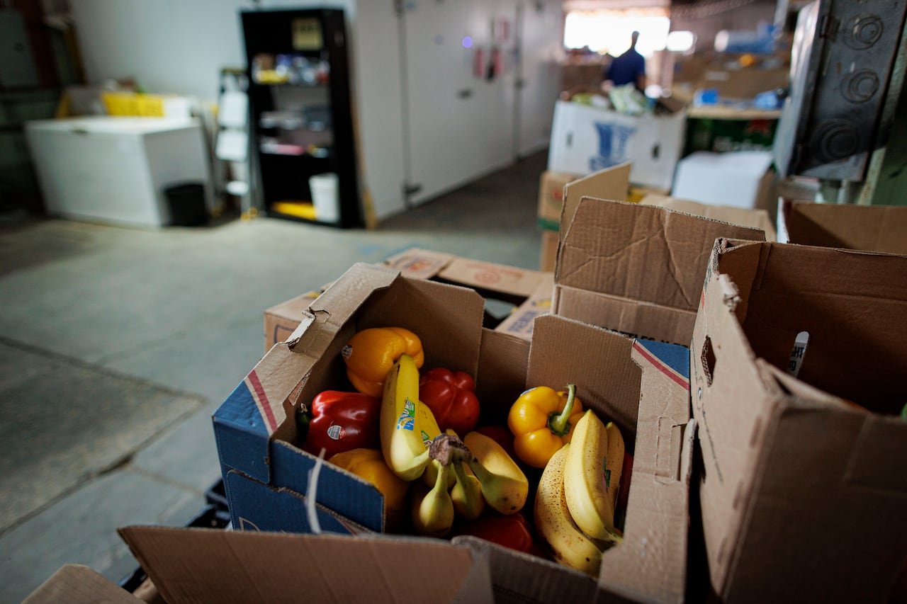 A box of fruits and vegetables in a warehouse.