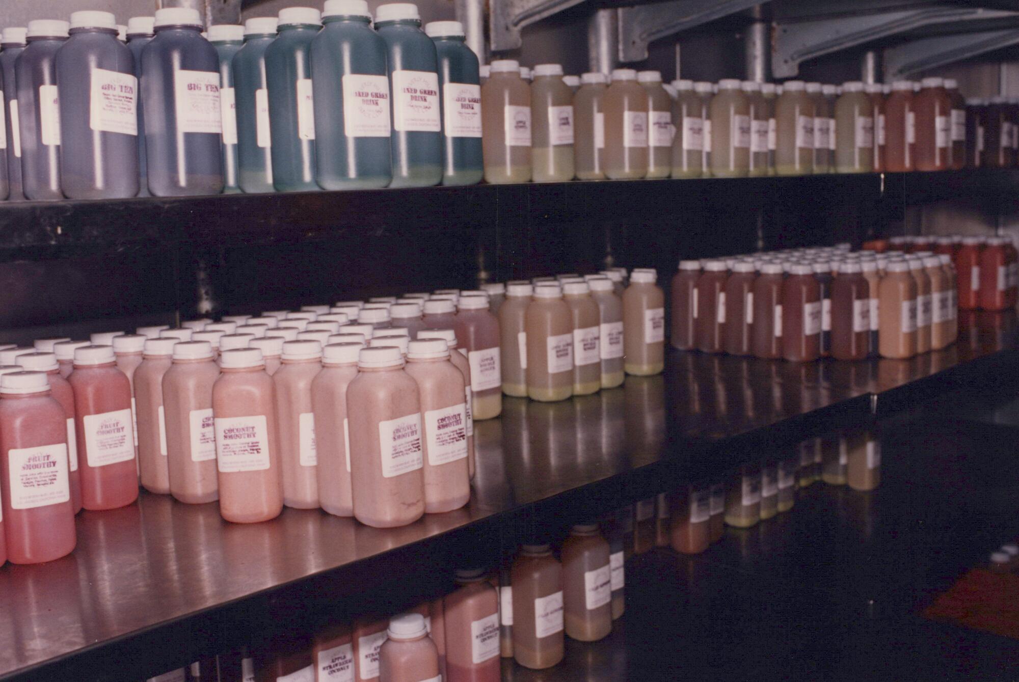 A rainbow of colors of juice in plastic bottles on shelves