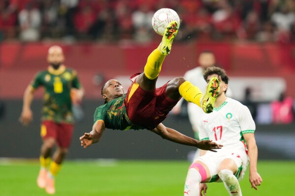 Cameroon's Che Malone, center, is in action during the Africa Cup of Nations quarterfinal soccer match between Cameroon and Morocco, in Rabat, Morocco, Friday, Jan. 9, 2026. (AP Photo/Mosa'ab Elshamy)