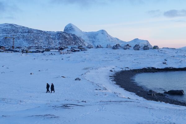 People walk on a beach in Nuuk, Greenland, on Thursday, Jan. 15, 2026. (AP Photo/Evgeniy Maloletka)