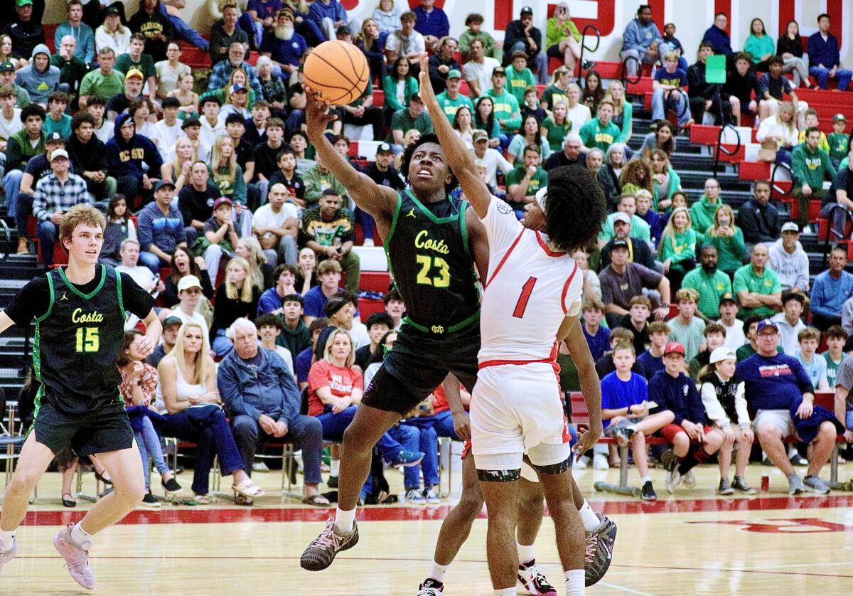 Mira Costa’s Paxx Bell scores on a layup over Redondo Union's Chace Holley.