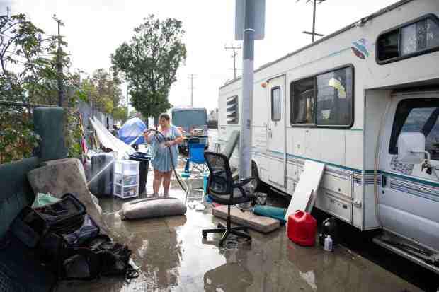 FILE - "It's going to be catastrophic without funding," says Saundra Macpherson, 53, who says she knows 20 people who have been housed as she hoses down bedding and pillows from the camper she shares with her sister and five dogs in Pacoima on Thursday, Sept. 18, 2025. Los Angeles County's Homeless Services and Housing Department is anticipating deep funding cuts in reducing homelessness for its upcoming budget. A budget hearing is expected before the LA County Board of Supervisors on Feb. 3, 2026. (Photo by Sarah Reingewirtz, Los Angeles Daily News/SCNG)