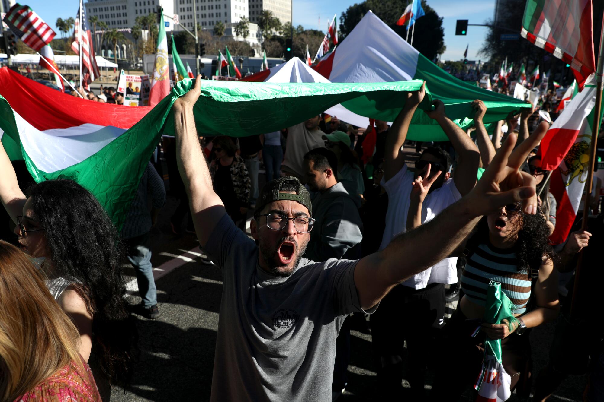 People march with an Iranian Pre-Revolutionary flag as Iranians gather for a Make Iran Great Again march / rally.