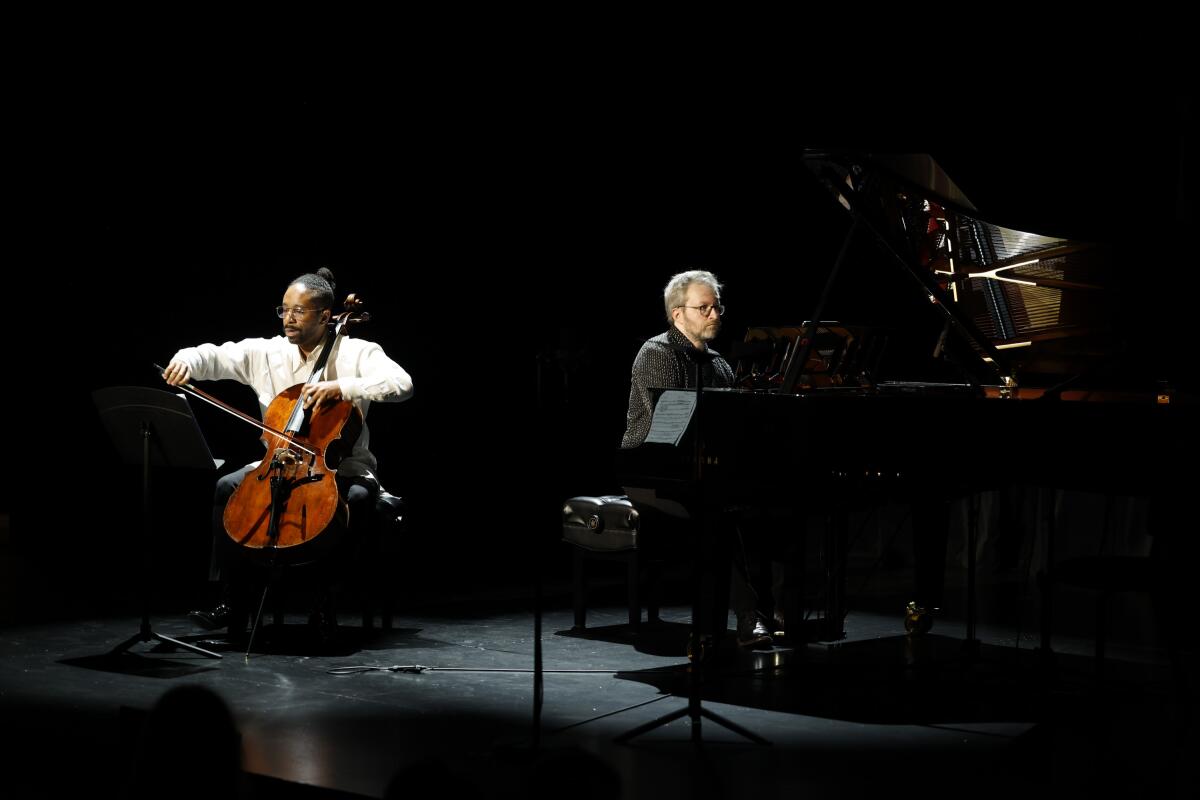  Cellist Seth Parker Woods and pianist Conor Hanick perform on a darkened stage