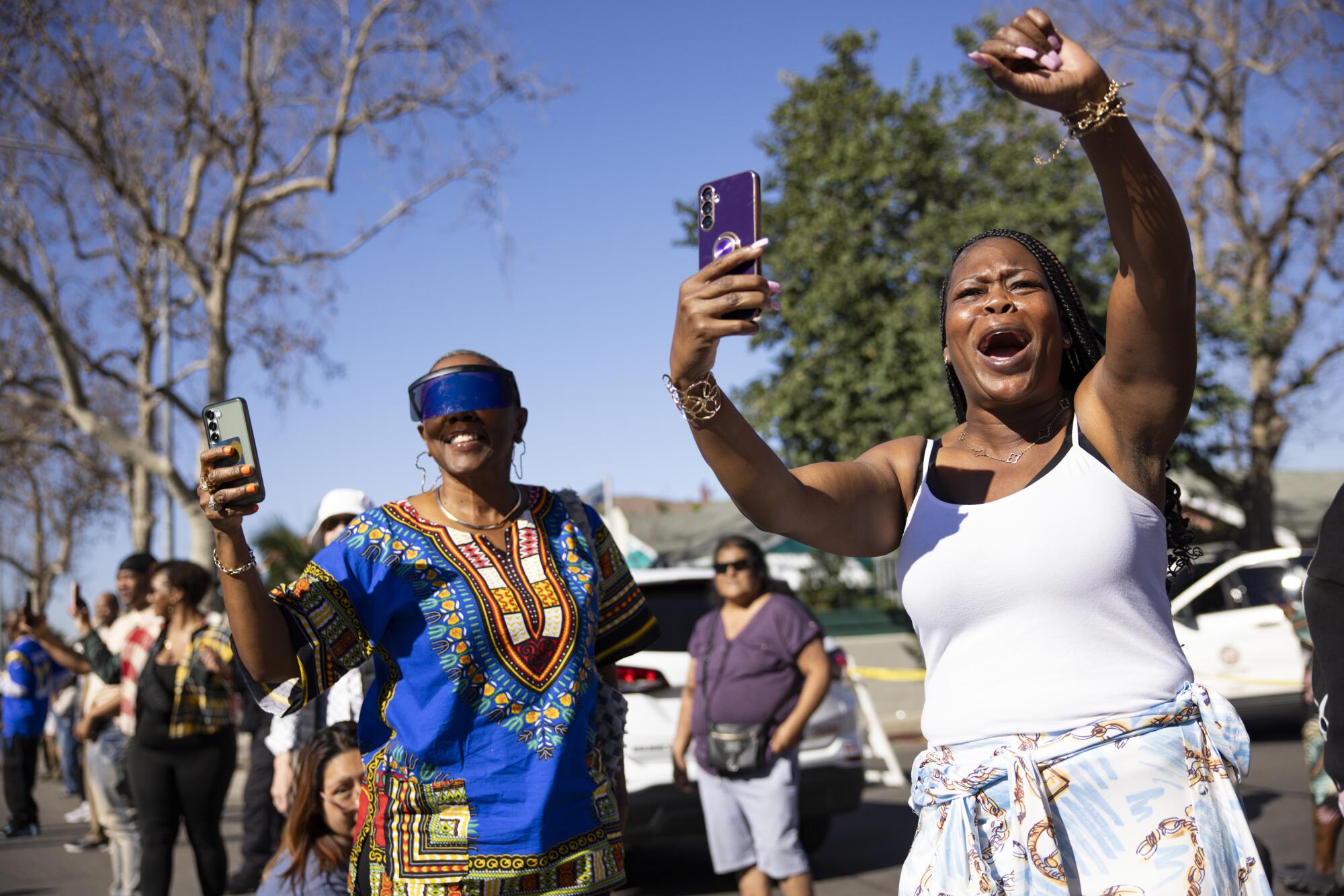 Theresa Vaughn and Nakisha Smith cheer for the Inglewood High School Marching Band.