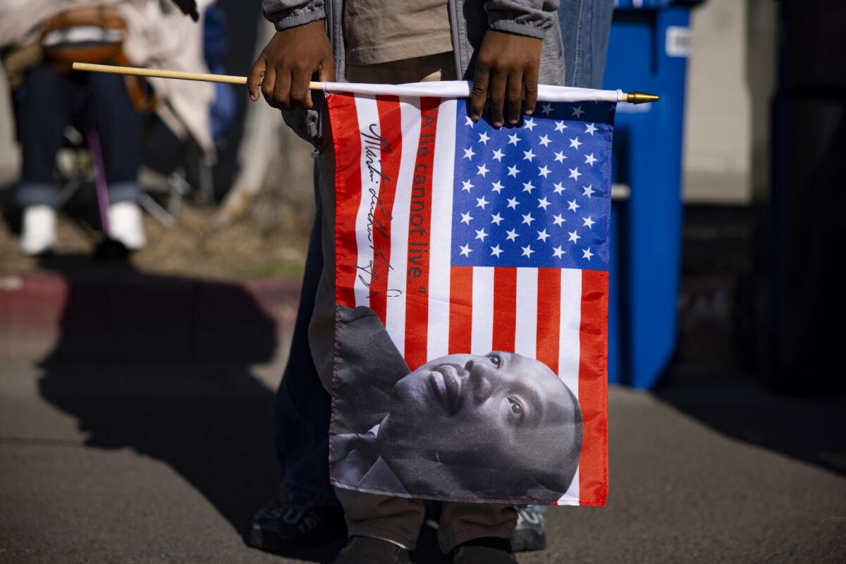 Zion See from Fontana holds a flag during the Dr. Martin Luther King Jr. Day Parade.