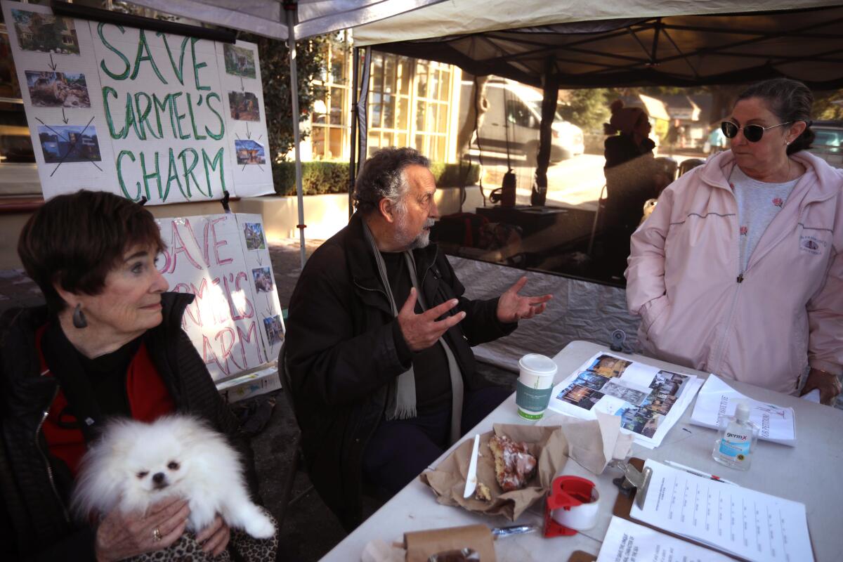 Neal Kruse, center, and Karyl Hall, with the Carmel Preservation Assn., talk to resident Lisa Ferchau about street addresses.