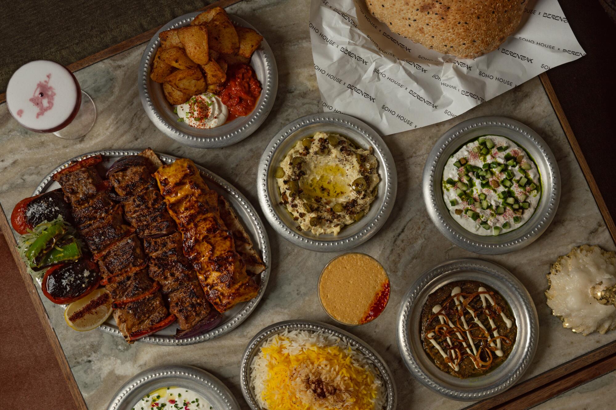 Spread of kebabs, side dishes and cocktails at Berenjak at Soho House in downtown Los Angeles.