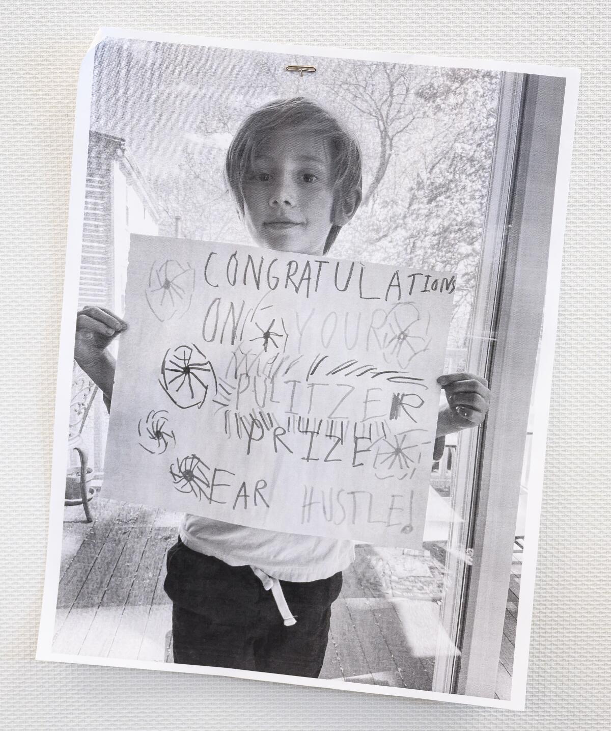 A young boy holds a hand-made sign. 