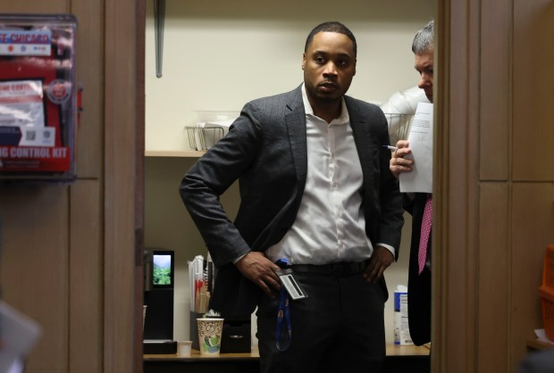 Jason Lee, senior adviser to Mayor Brandon Johnson, and Ald. Brian Hopkins, 2nd, speak in a room outside chambers during a City Council meeting on Jan. 21, 2026, at Chicago's City Hall. (Brian Cassella/Chicago Tribune)