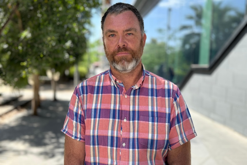 Andrew Watkins wearing a pink and purple checked shirt.
