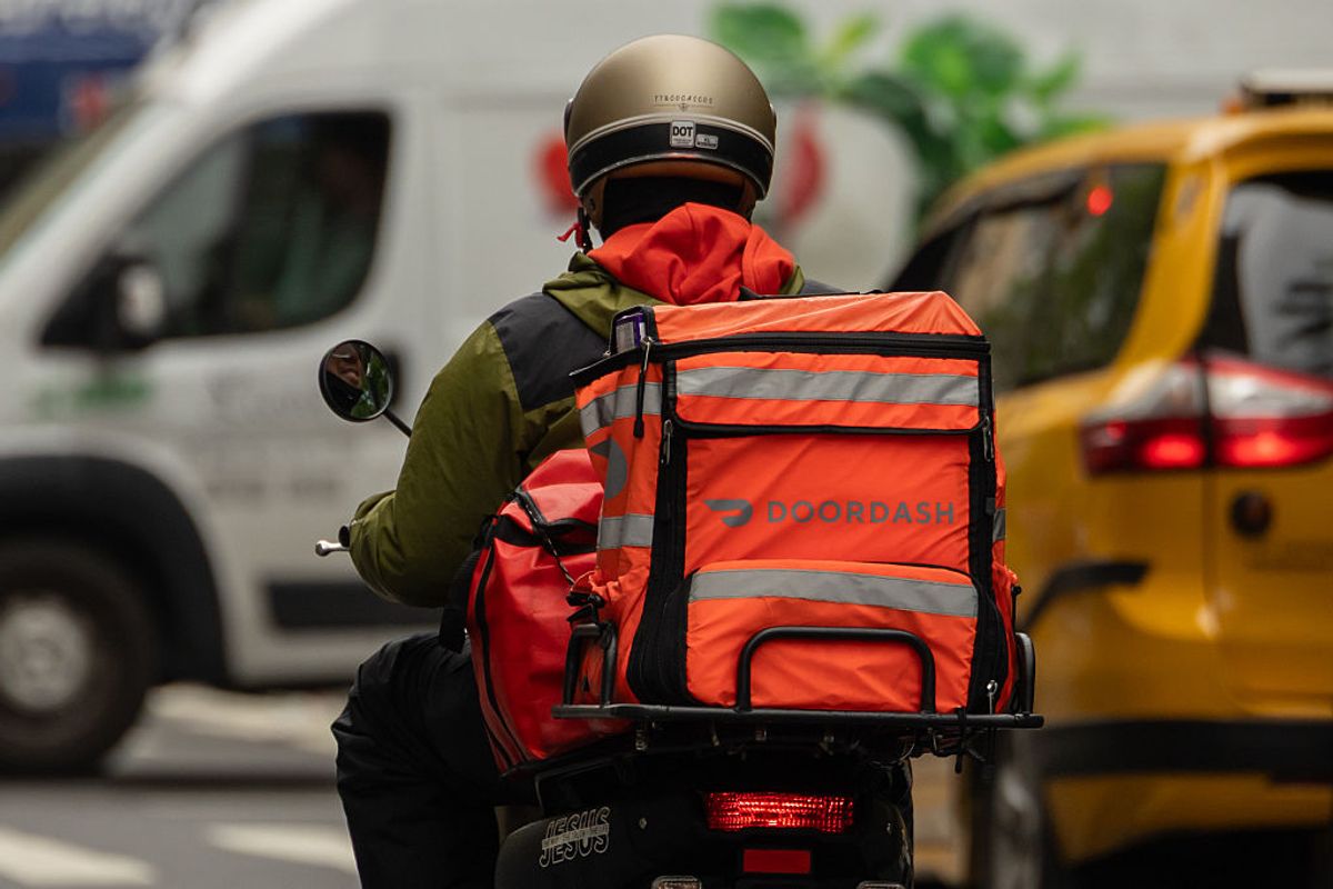 A delivery worker carries a DoorDash bag in New York, US, on Tuesday, May 6, 2025. 