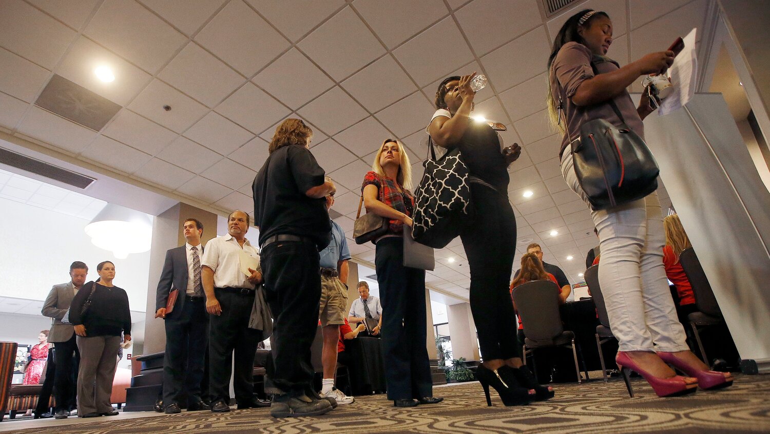People line up to attend a State Farm Career Fair, Tuesday, Aug. 4, 2015, in Phoenix.