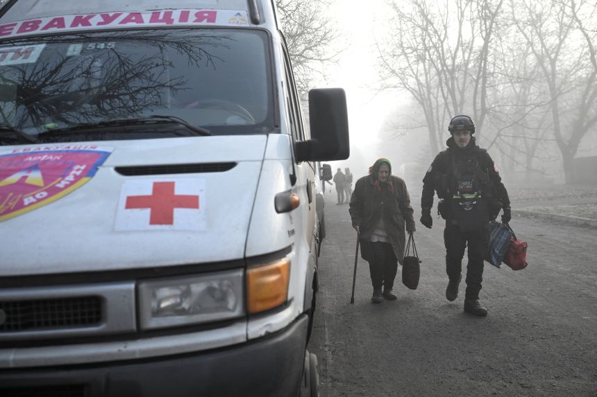 A police officer assists a woman after evacuating from the frontline town of Huliaipole, amid Russia's attack on Ukraine, in Zaporizhzhia region, Ukraine November 14, 2025.