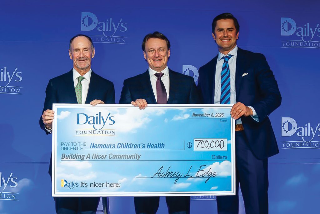 Edge and two other men holding large check