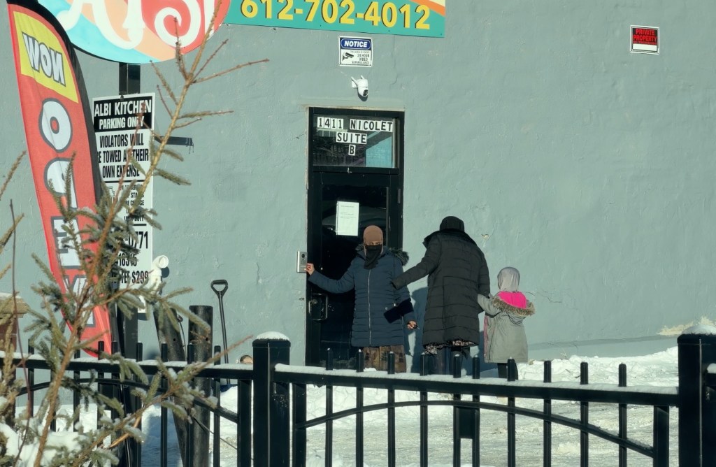 Adults and children arrive at the "Quality Learning Center" day care in Minneapolis, Minnesota.