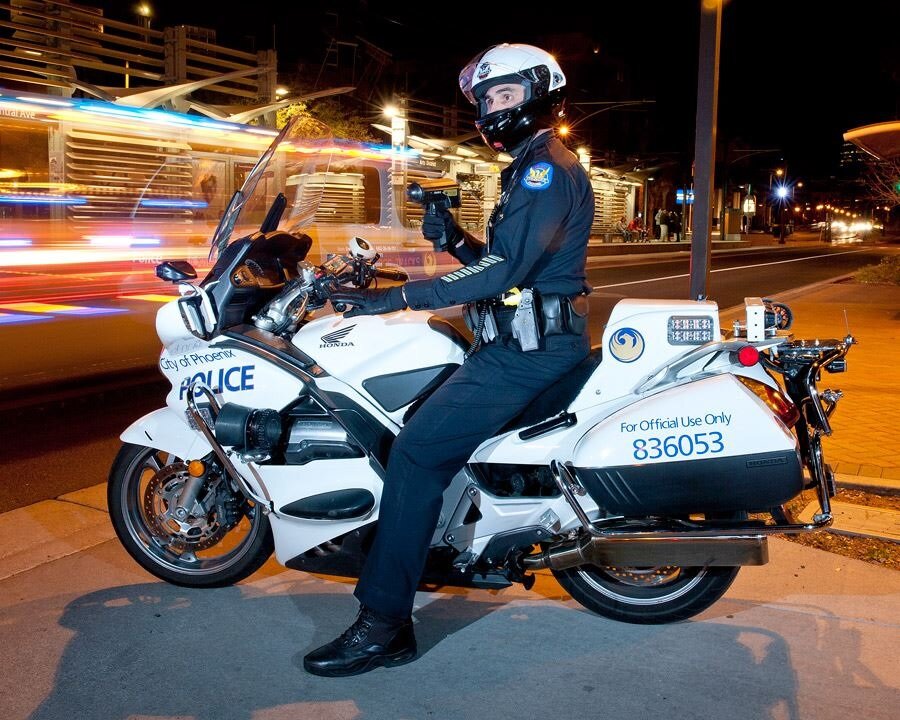 A Phoenix Police officer checks vehicles