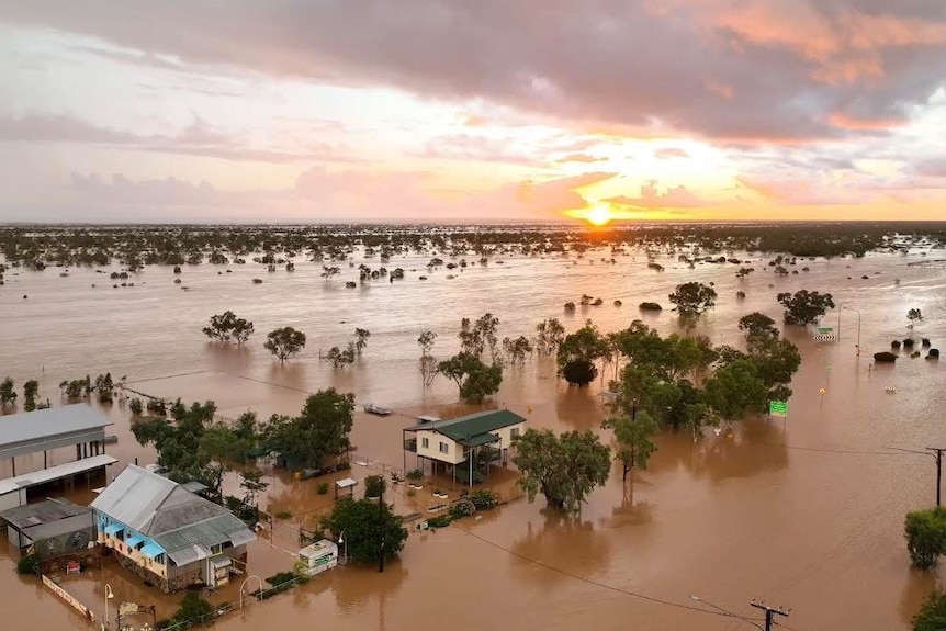 aerial of floodwaters around houses and trees.