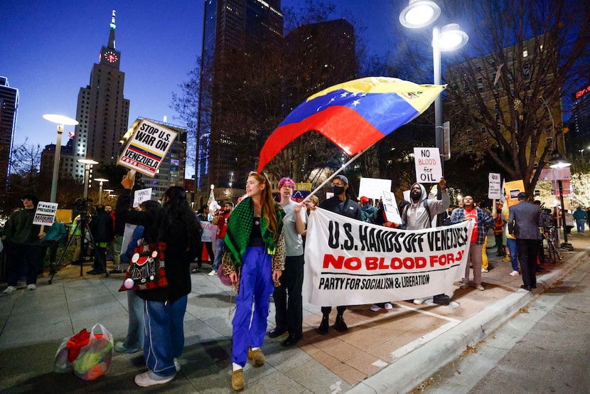 Demonstrators carry signs and chant at the corner of Commerce and Harwood Streets during a...