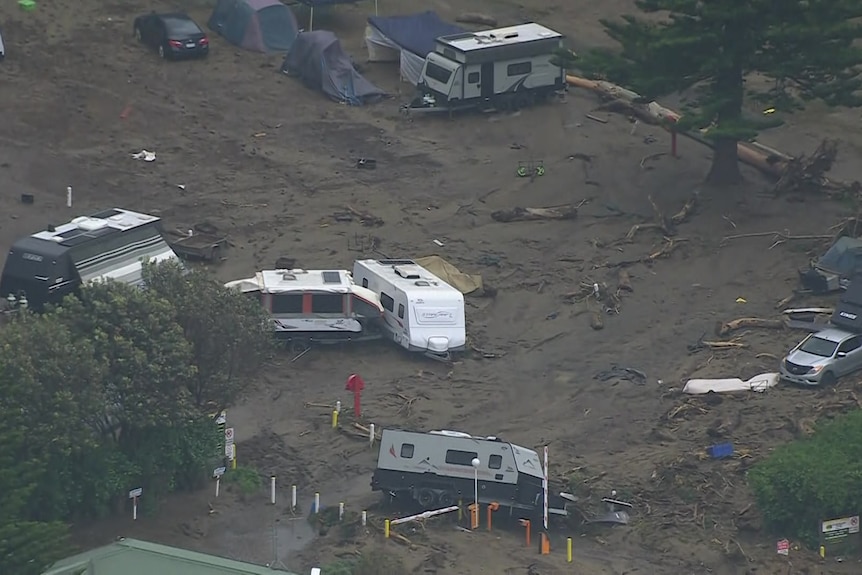 An aerial view of caravans tossed about and surrounded by mud.