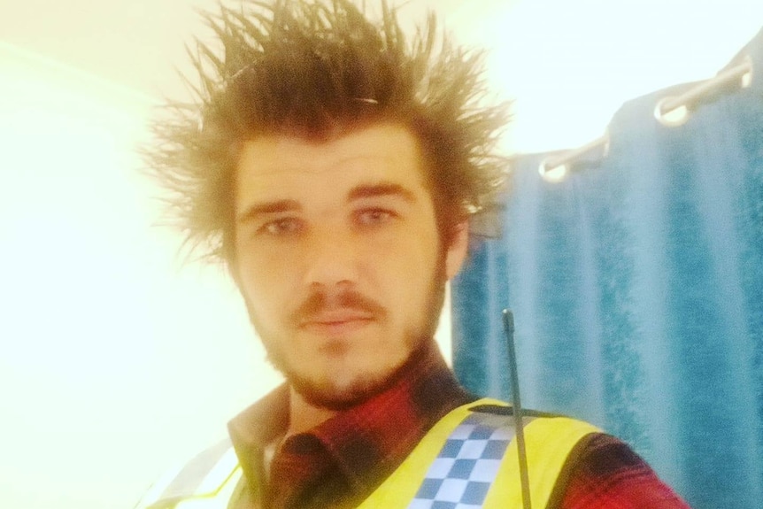 A man with brown hair taking a selfi