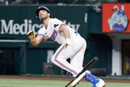 Texas Rangers batter Josh Smith watches his fifth inning bunt shoot high in the air and...