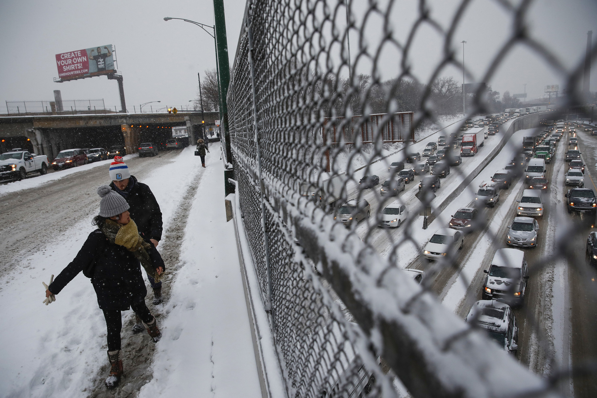 Pedestrians walk to the CTA Montrose Blue Line station in...